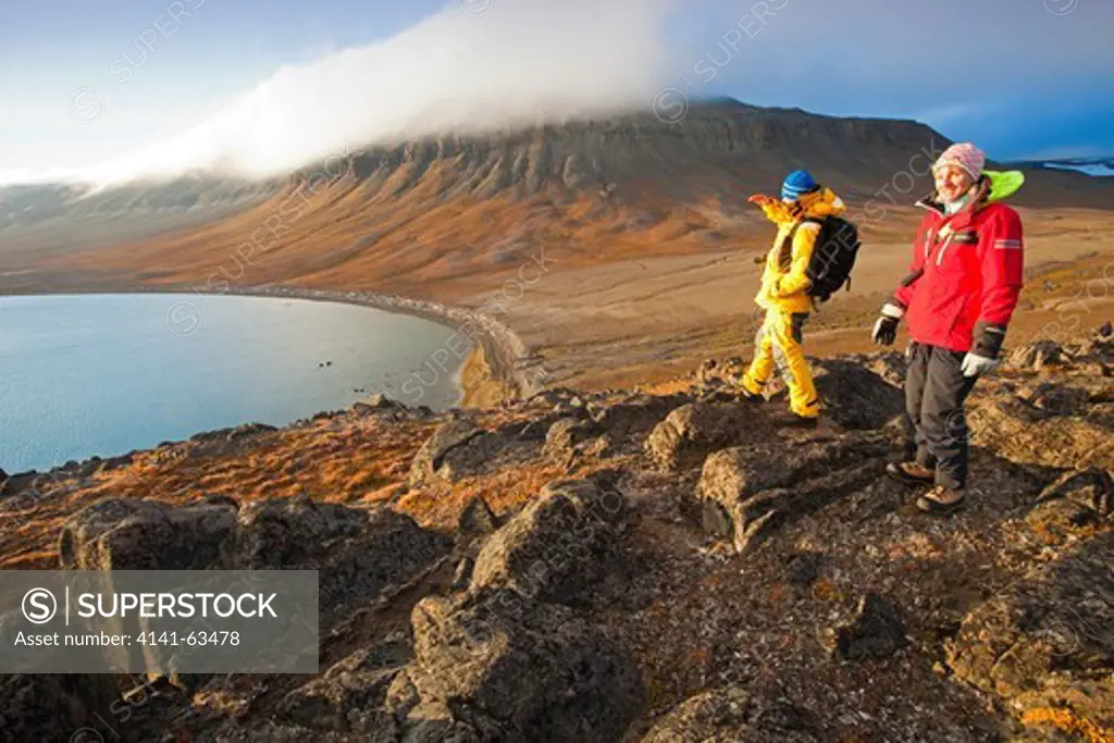 Arctic Tundra  Tourists Enjoy The View Across The Ice-Free Tundra And Mountains Of Barentsoya Off The East Coast Of Spitsbergen. Summer.  Barentsoya, Svalbard, Norway