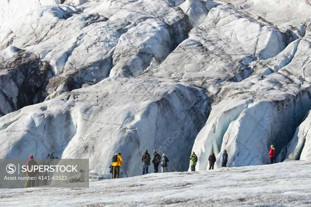 Glacier  People Stand At The Leading Edge Of A Highly Crevassed Glacier.  Spitsbergen, Svalbard, Arctic