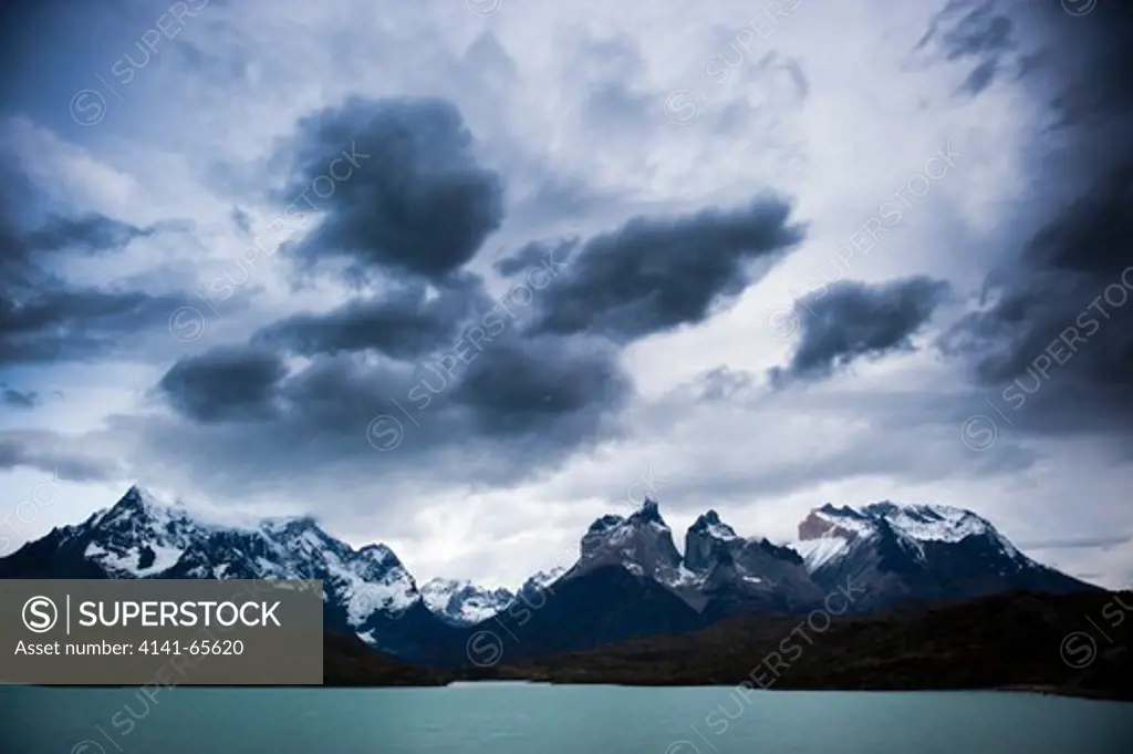 Storm clouds over the Cuernos and Paine Grande, seen from Lago Pehoe, Torres del Paine National Park, Chile. Torres del Paine National Park is a Chilean National Park, and Unesco Biosphere Reserve, of almost 6 million acres in size encompassing mountains, glaciers, lakes, and rivers in the Patagonia region of southern Chile.