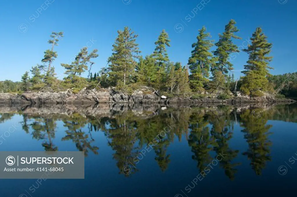 Scenic of freshwater lake, boreal forest and island of Canadian Shield rock in Quetico Provincial Park, Ontario.