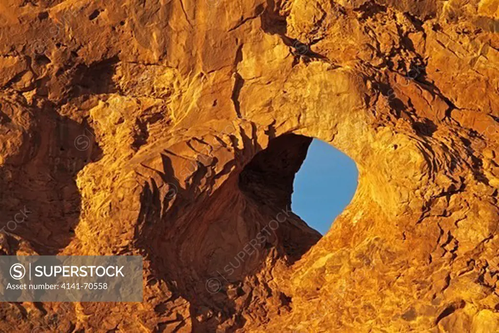 A close up of Turret Arch bathing in sunset light in Arches National Park, Utah.