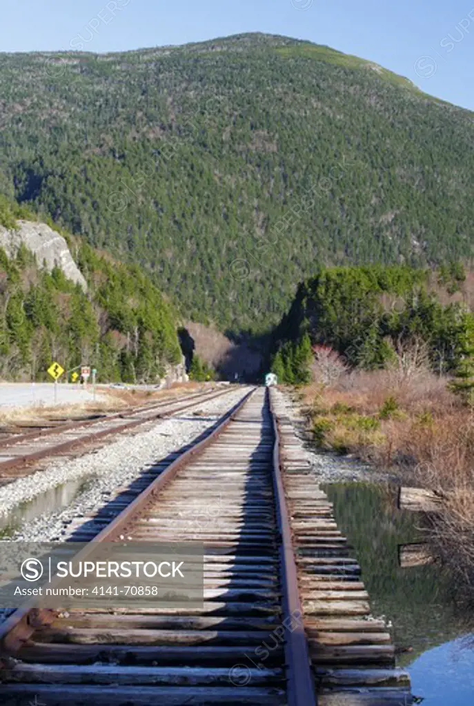 Railroad tracks next to Crawford Train Depot (Conway Scenic Railroad) at the start of Crawford Notch State Park in the White Mountains, New Hampshire USA. The rock profile known as 'Elephant Head'  can be seen on the left