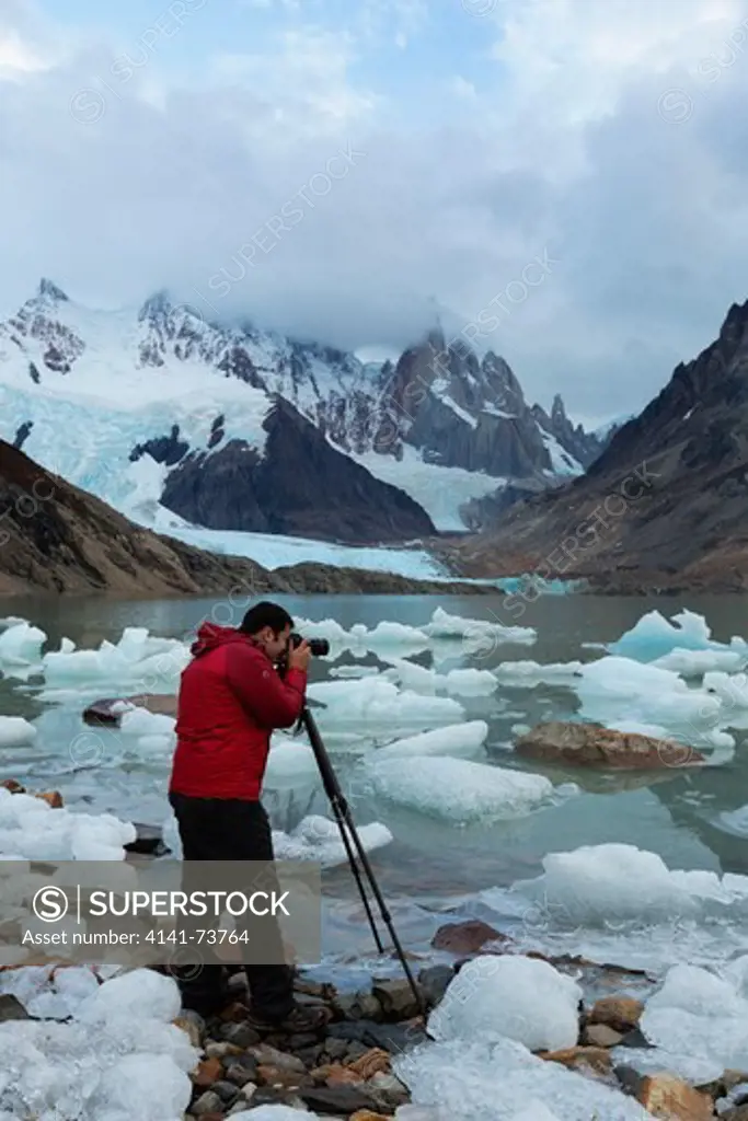 Tourist photographing Icy glacier waters of Lago Torre and Cerro Torre mountains in the  background.Patagonia.Argentina