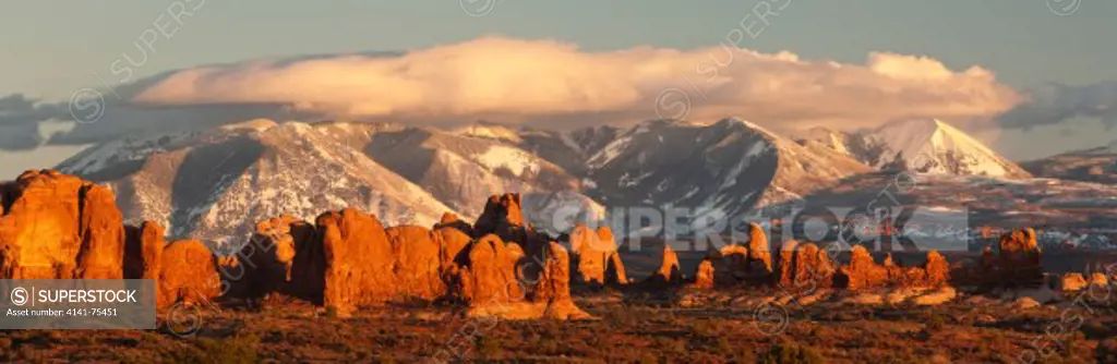 Sandstone forms and the LaSal Mountains at sunset, seen from Balanced Rock area; Arches National Park, Utah.