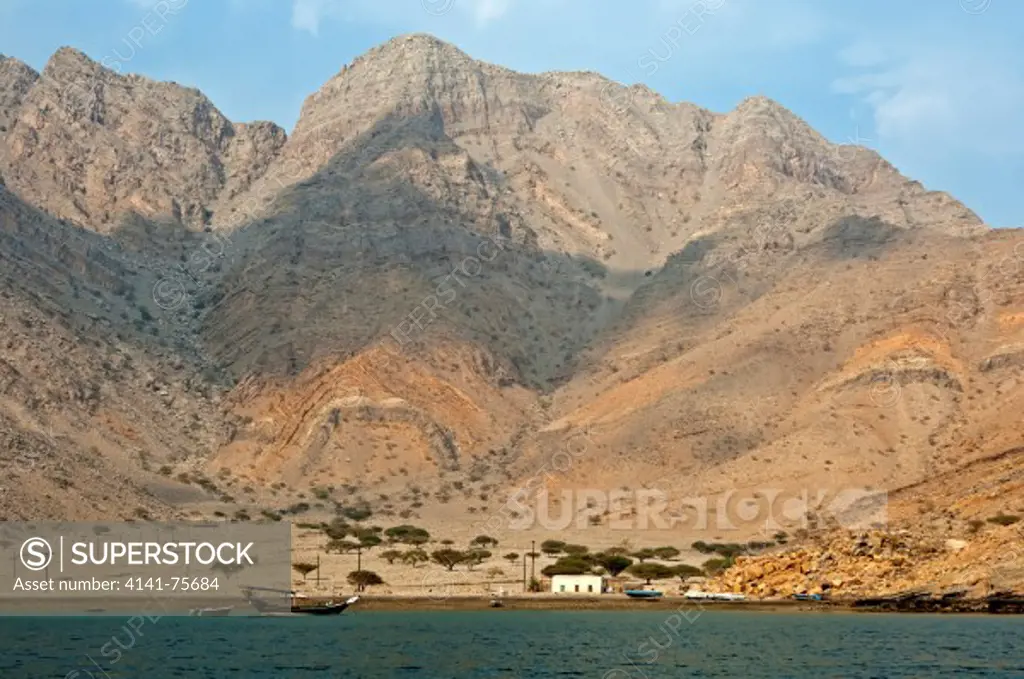 The remote village of Sham at the foot of a barren mountain range in the Khor Ash Sham Fjord, Musandam, Sultanate of Oman