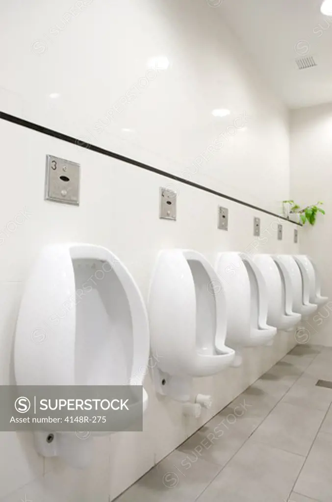A mens public bathroom with urninals on the wall