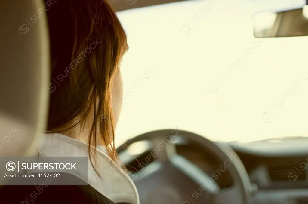 Rear view of a woman driving a car