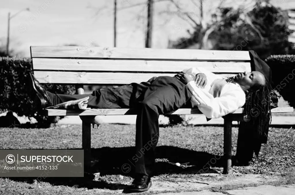 Businessman lying on a bench