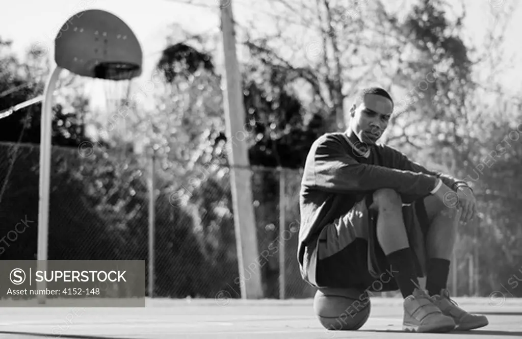 Man sitting on a basketball