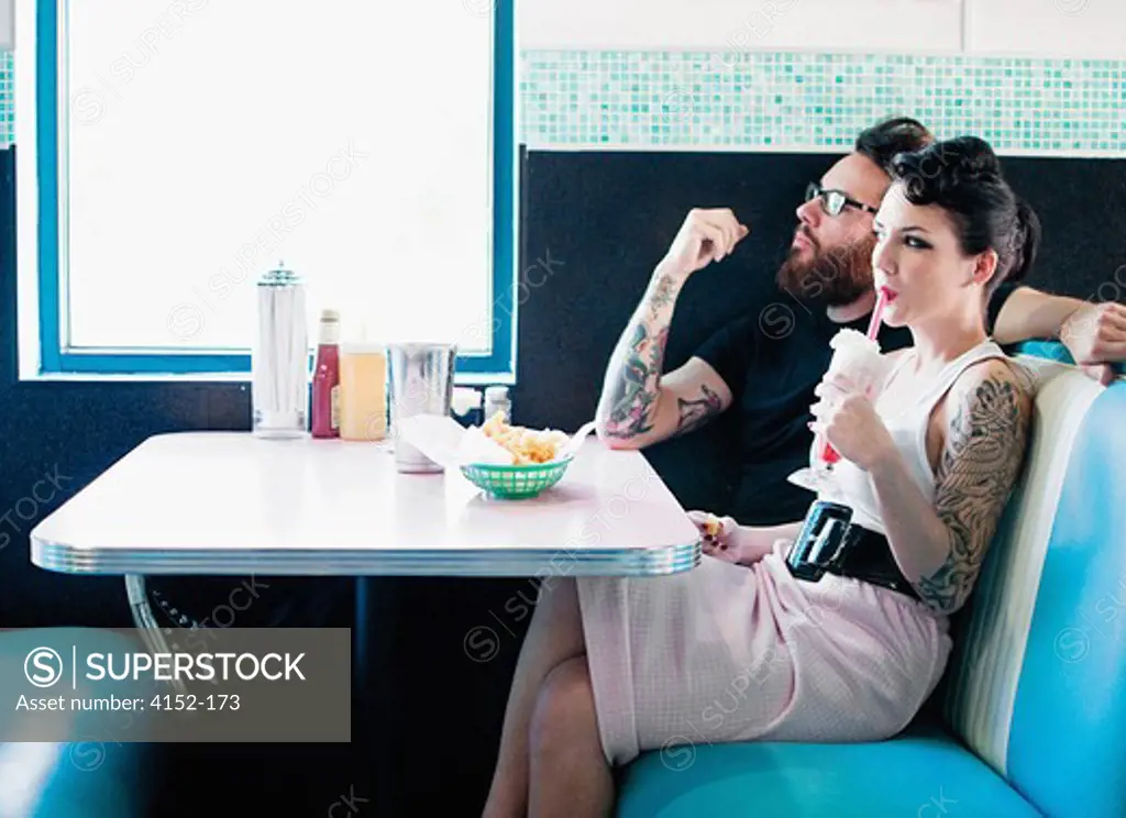 Couple having milkshake and snacks in a restaurant