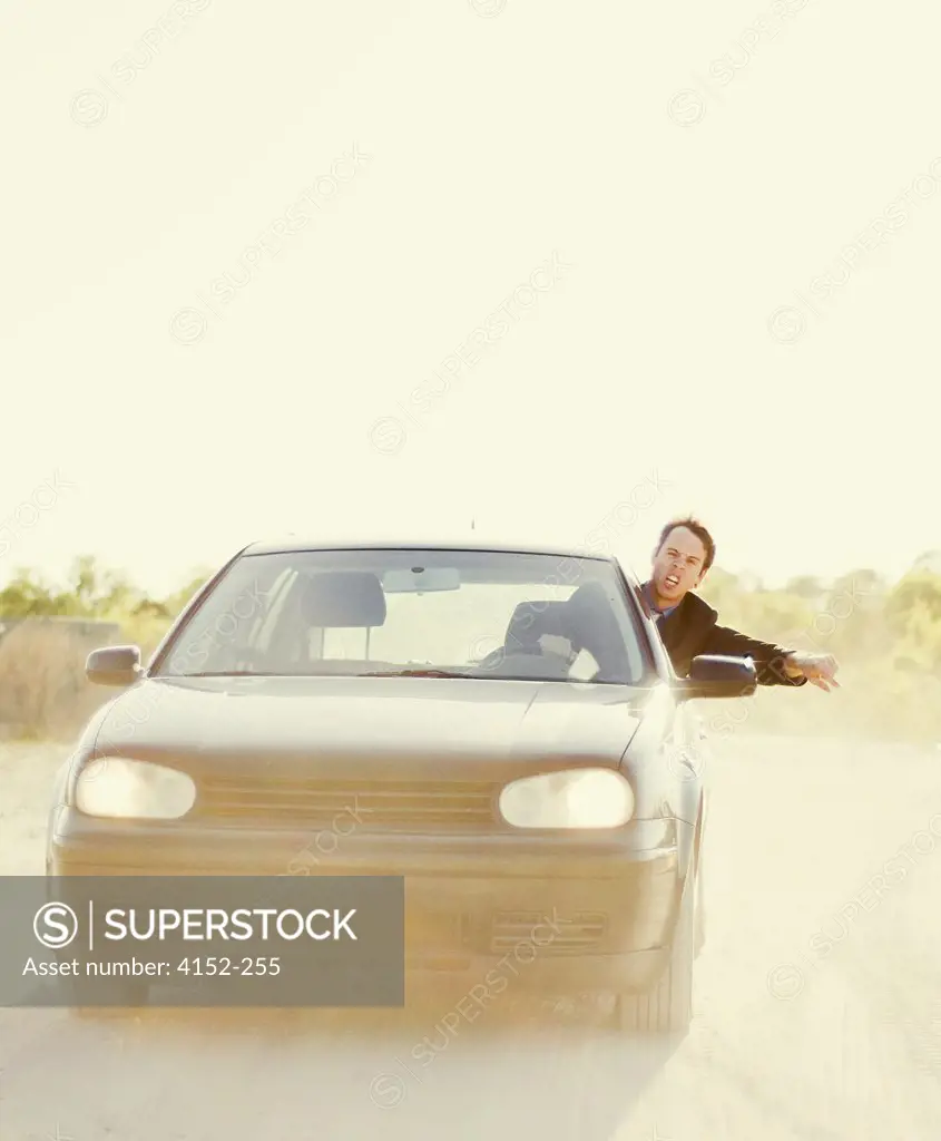 Young businessman gesturing while driving a car
