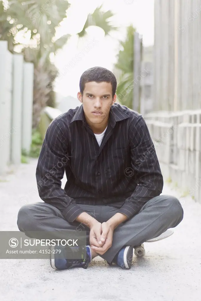 Portrait of a young man sitting on a skateboard
