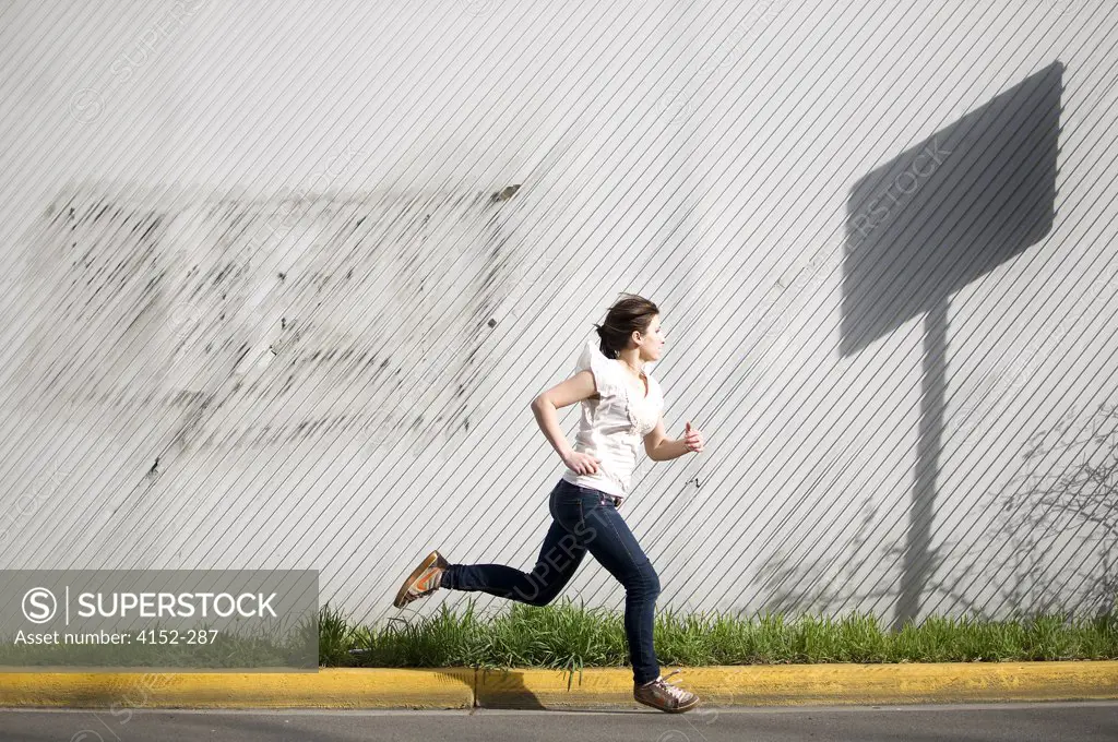 Young woman running on a street