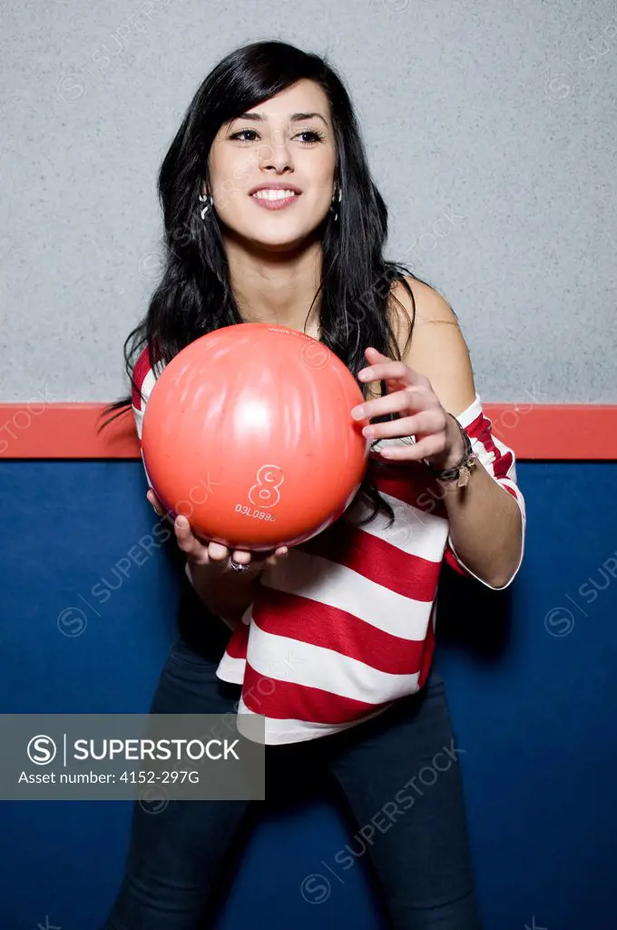 Young woman holding a bowling ball and smiling