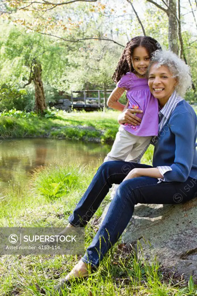 USA, Grandmother and granddaughter near pond