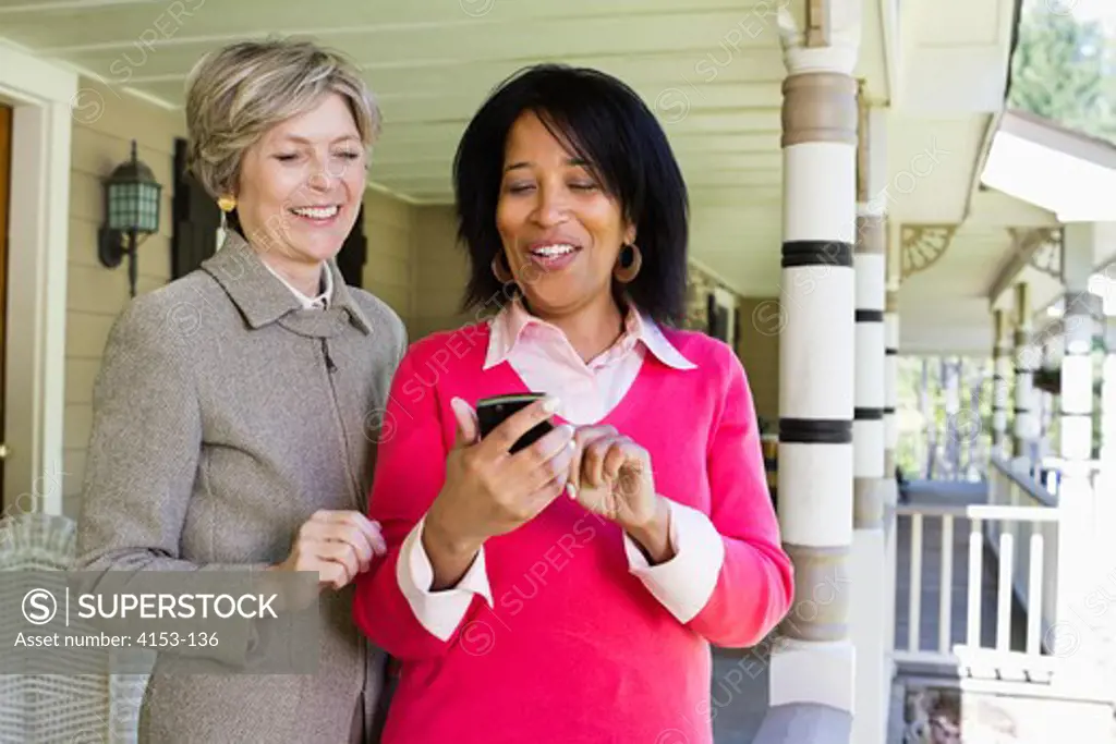 USA, Two mature women looking at Blackberry smart phone