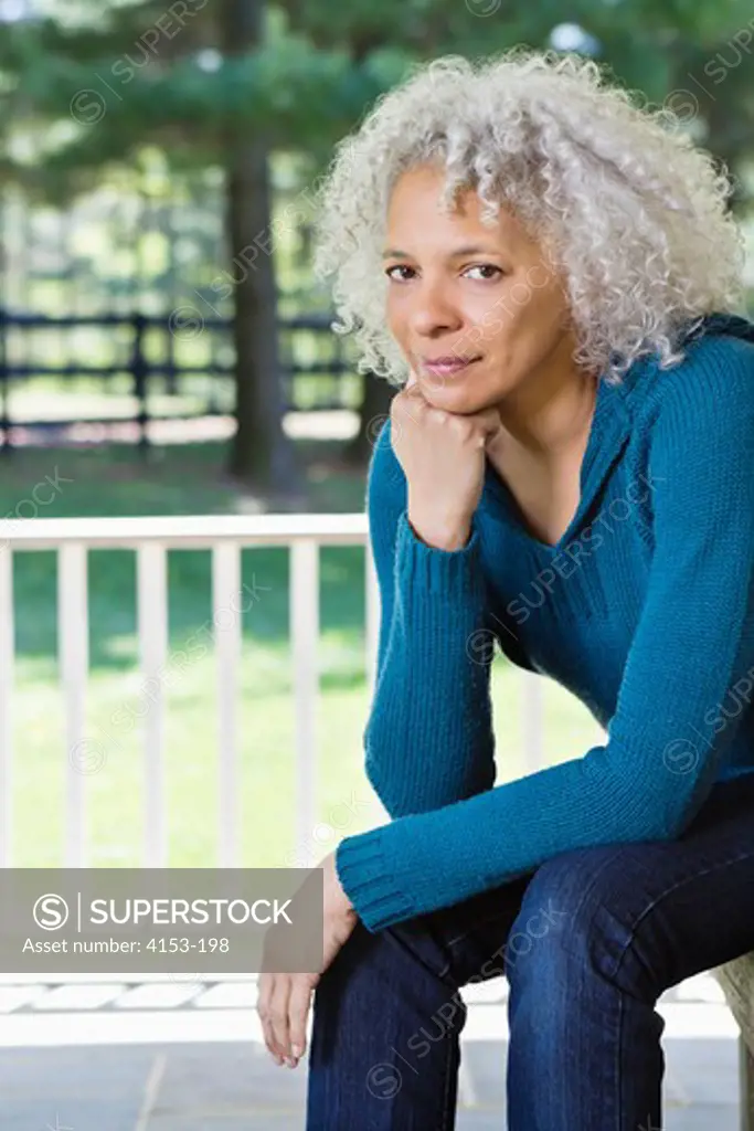 USA, Mature woman sitting on porch, portrait