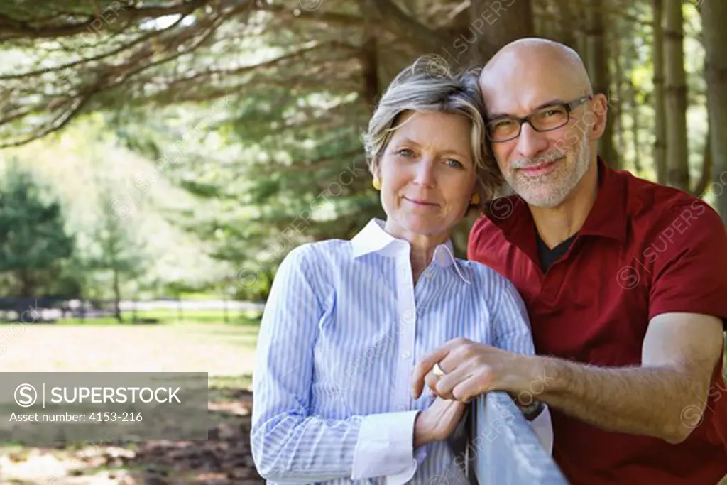 USA, Portrait of mature couple leaning on rail fence