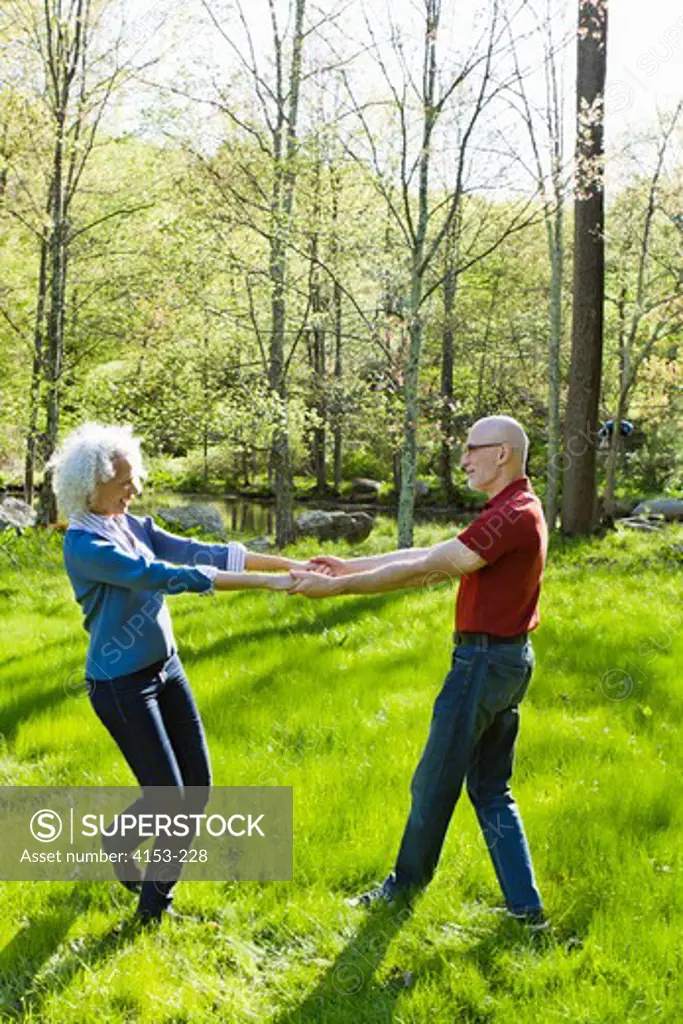 USA, Mature couple dancing on meadow