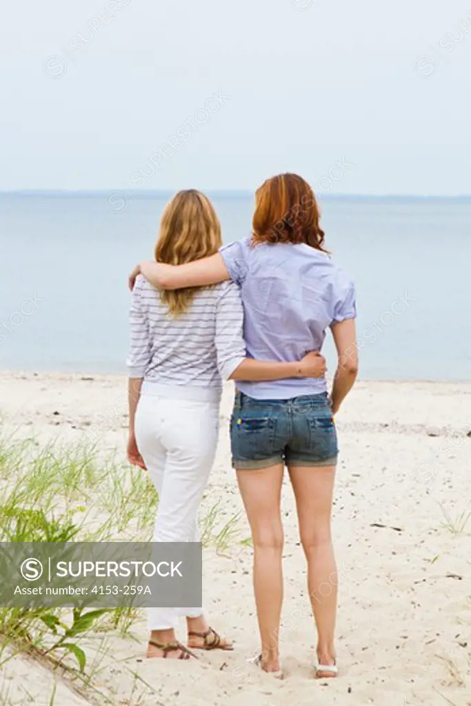 Rear view of two young women embracing on beach