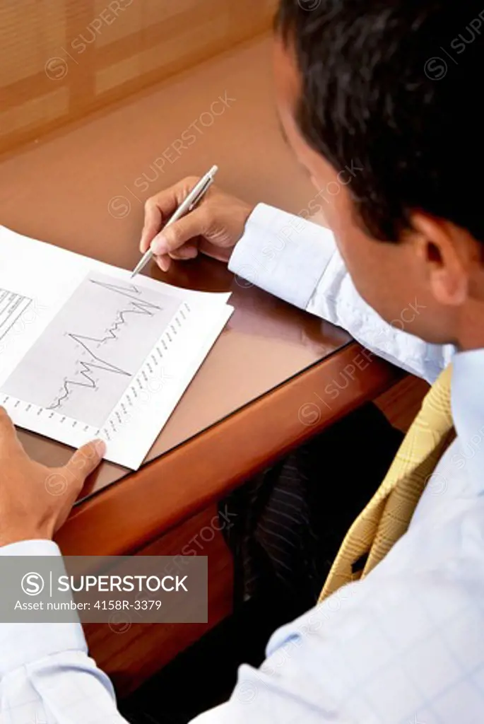business man writing on a financial report where you can see the company growth