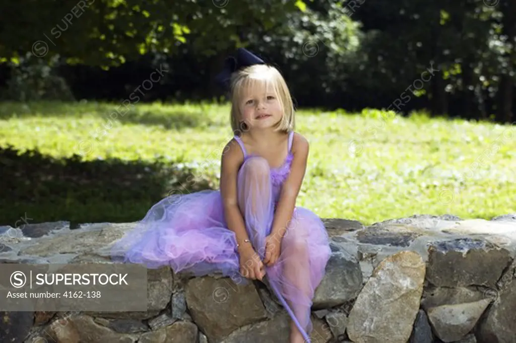 Girl sitting in a fairy costume in a park