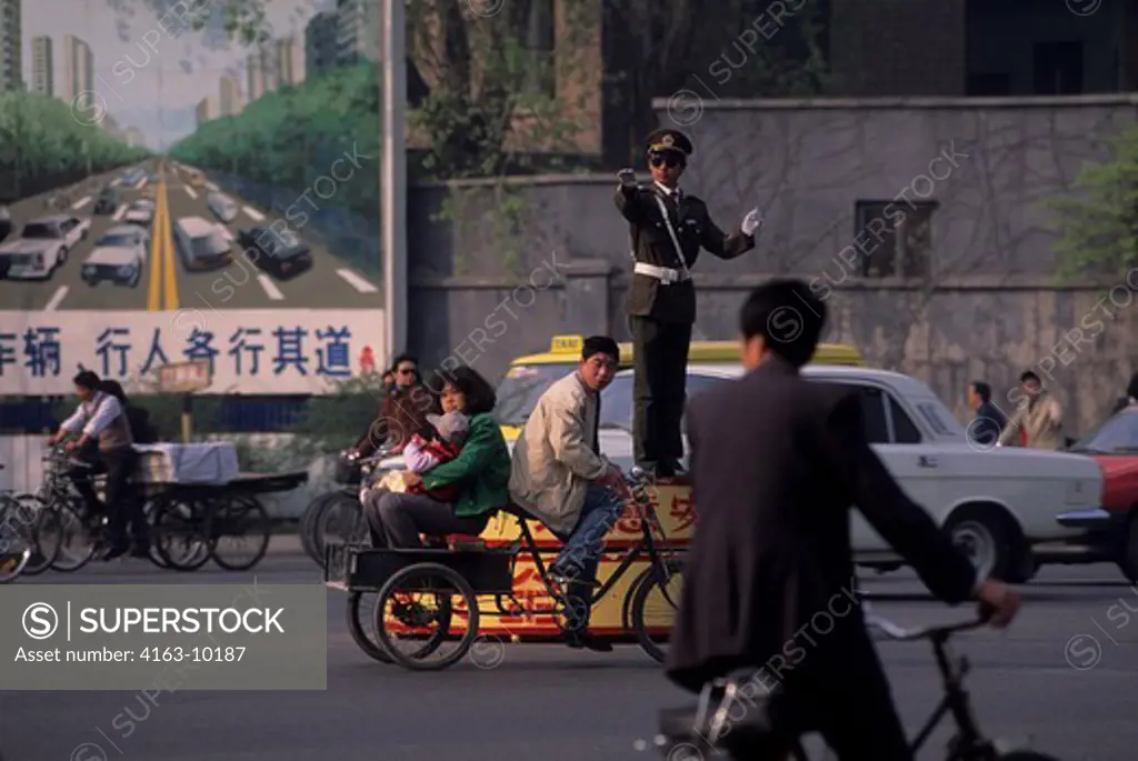 CHINA, BEIJING, STREET SCENE, POLICEMAN DIRECTING TRAFFIC