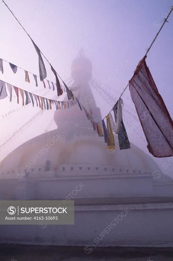 NEPAL, KATHMANDU, BOUDHNATH, TIBETAN STUPA (TEMPLE) IN FOG, PRAYER FLAGS