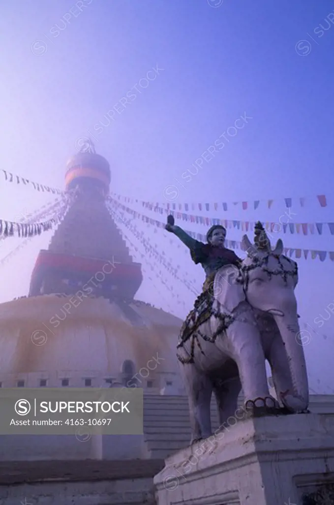 NEPAL, KATHMANDU, BOUDHNATH, TIBETAN STUPA (TEMPLE) IN FOG, PRAYER FLAGS, STATUE