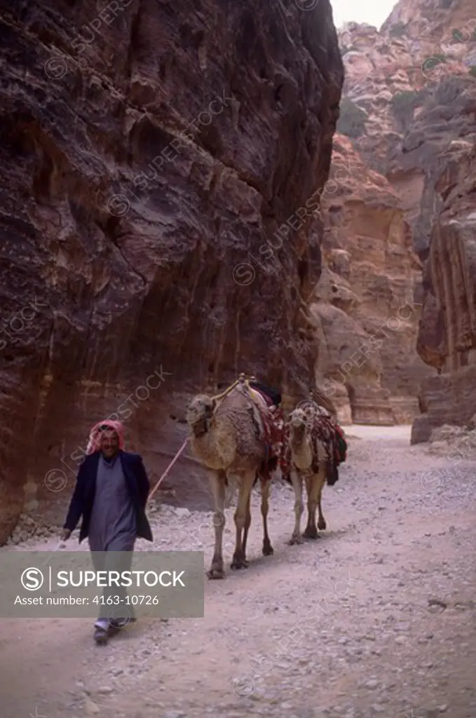 JORDAN, PETRA, THE SIQ GORGE, ENTRANCE WAY TO THE CITY OF PETRA, MAN WITH CAMELS