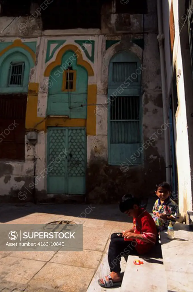 SAUDI ARABIA, JEDDAH, OLD TOWN, STREET SCENE WITH CHILDREN AND COLORFUL DOOR