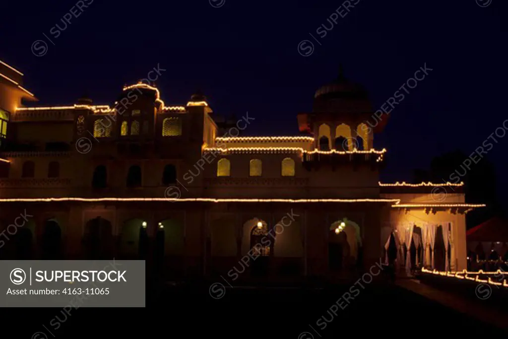 INDIA, JAIPUR, HOTEL RAMBAGH PALACE, A FORMER PALACE OF THE MAHARAJAS OF JAIPUR, AT NIGHT