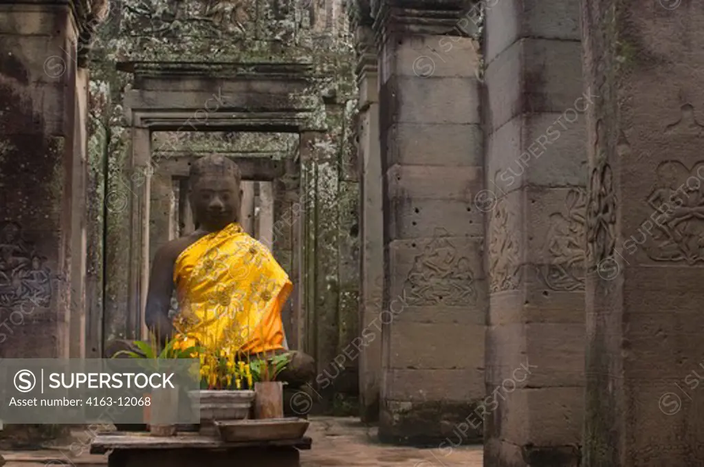 CAMBODIA, ANGKOR, ANGKOR THOM, BAYON TEMPLE, BUDDHA STATUE WITH OFFERINGS