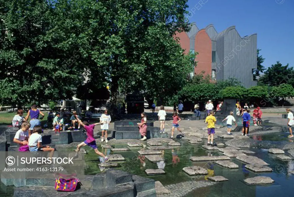 GERMANY, COLOGNE, CHILDREN PLAYING IN PARK IN FRONT OF ROMAN-GERMANIC MUSEUM