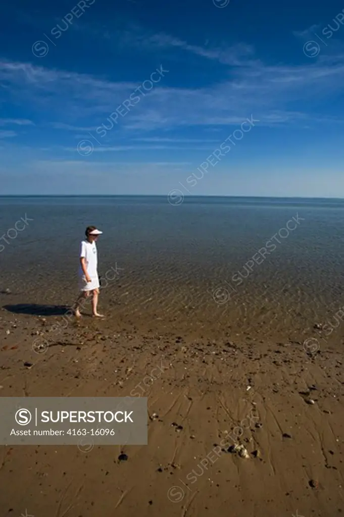 GERMANY, SCHLESWIG HOLSTEIN, NORTH SEA, NORTH FRISIAN ISLANDS, SYLT ISLAND, LIST, WOMAN WALKING ON BEACH AT LOW TIDE, MODEL RELEASED
