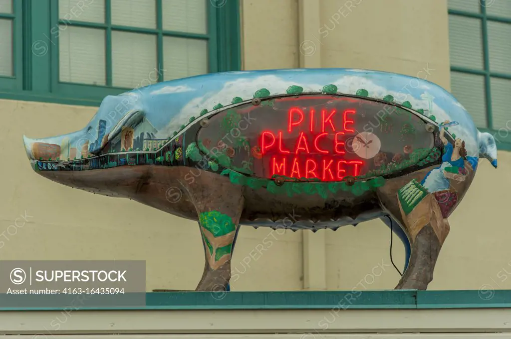 A pig statue with a neon Pike Place Market sign at the Pike Place Market in Seattle, Washington State, USA.