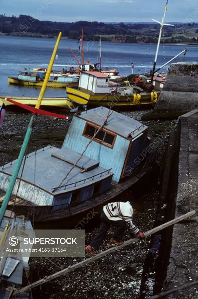 CHILE, (SOUTHERN CHILE) CHILOE ISLAND, DALCAHUE, LOCAL BOATS AT LOW TIDE