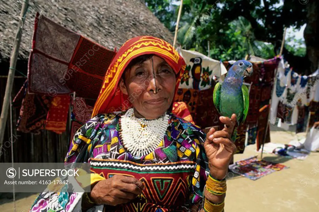 PANAMA, SAN BLAS ISLANDS, ACUATUPU ISLAND, KUNA INDIAN WOMAN WITH PET PARROT