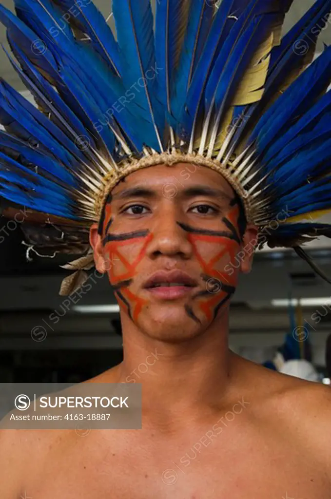 BRAZIL, MATO GROSSO, PORTRAIT OF NATIVE INDIAN MAN WITH MACAW FEATHER HEADDRESS