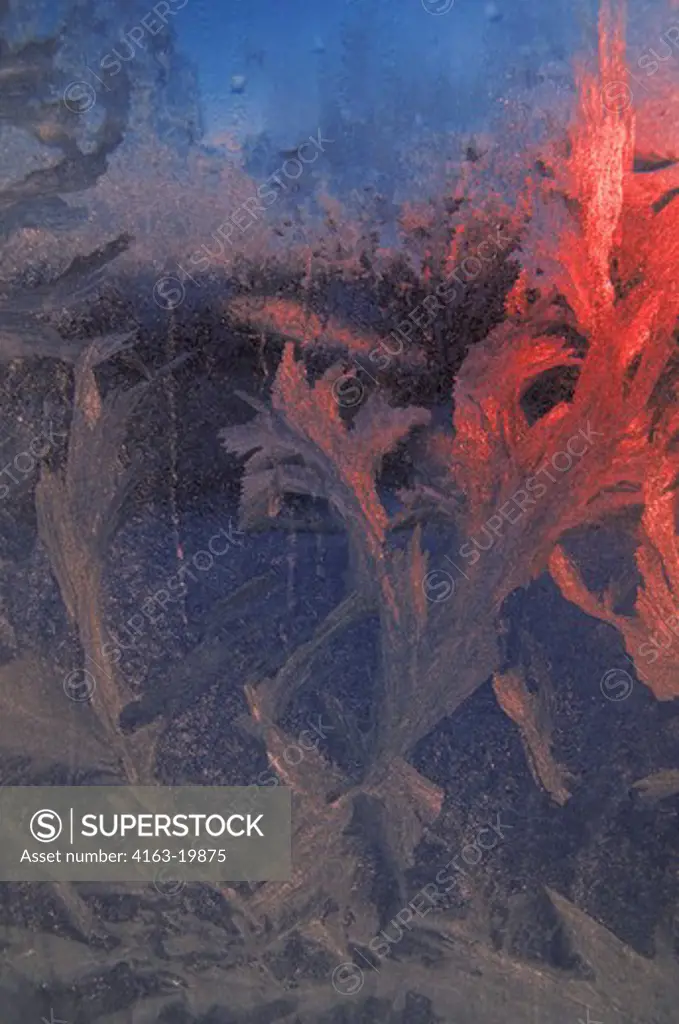 WINTER, ICE CRYSTALS PATTERNED ON FROSTED GLASS OF WINDOW