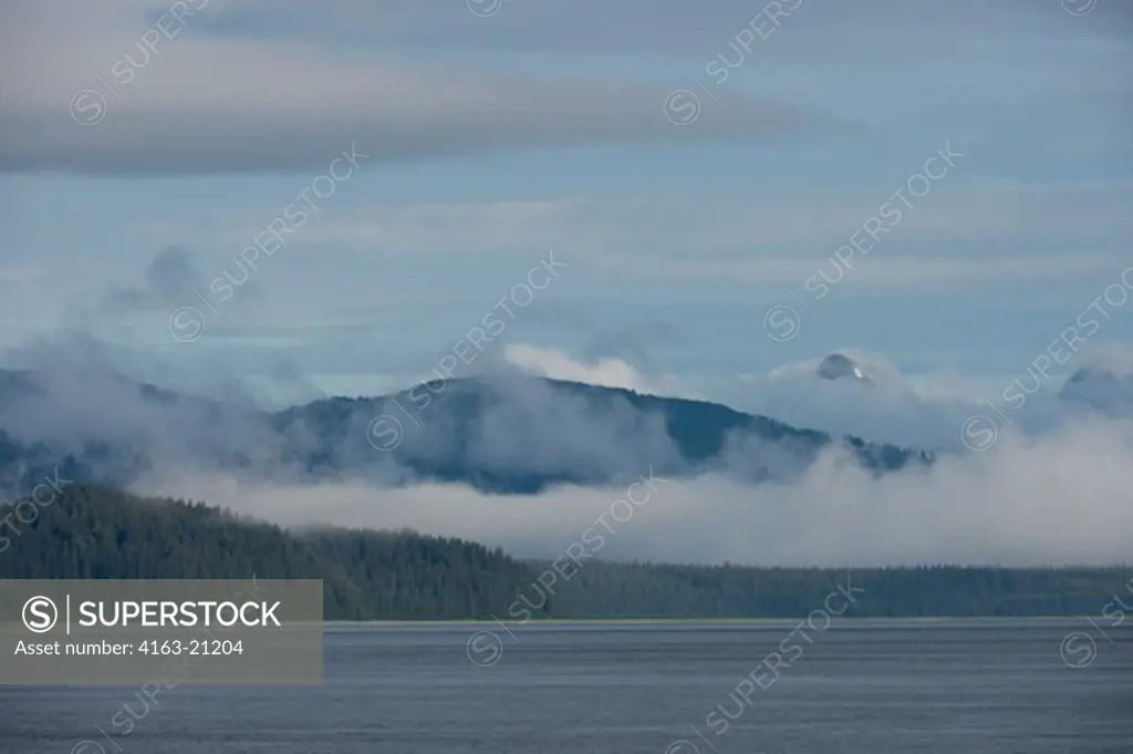 View of mountains with fog clearing at Sitakaday Narrows near Bartlett Cove, Glacier Bay National Park, Alaska, USA