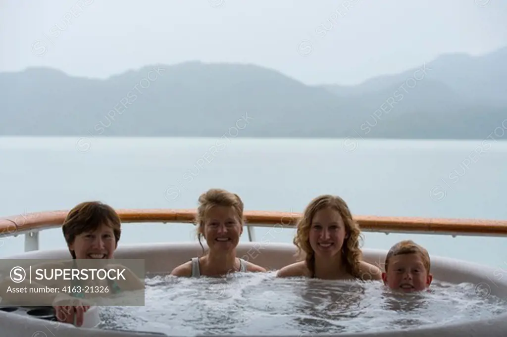 Passengers enjoying the hot tub on the cruise ship Safari Endeavour anchgored at Scenery Cove, Thomas Bay, Tongass National Forest, Alaska, USA