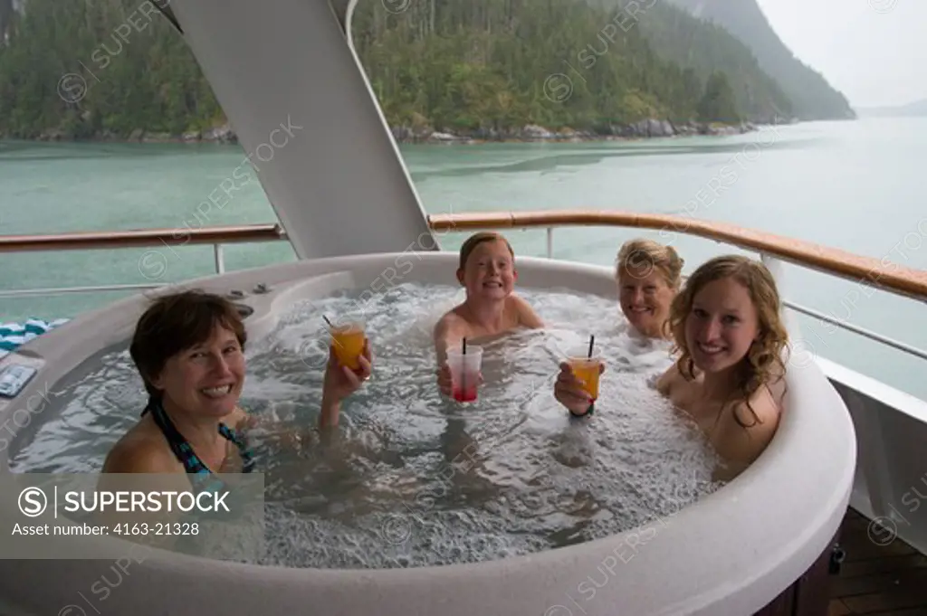 Passengers enjoying the hot tub on the cruise ship Safari Endeavour anchored at Scenery Cove, Thomas Bay, Tongass National Forest, Alaska, USA