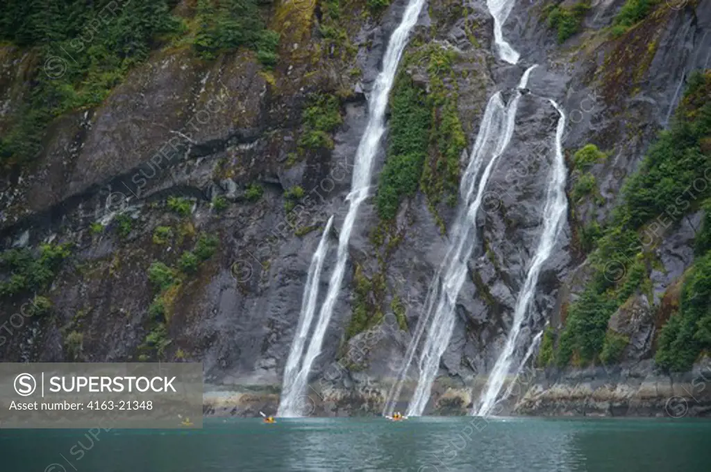 People sea kayaking in front of waterfall at Fords Terror, Endicott Arm, Tongass National Forest, Alaska, USA