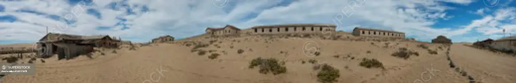 Panorama photo (79 inches x 13 inches) buildings in the abandoned (1954) German diamond mining settlement of Kolmanskop (ghost town) near Luderitz, Namibia