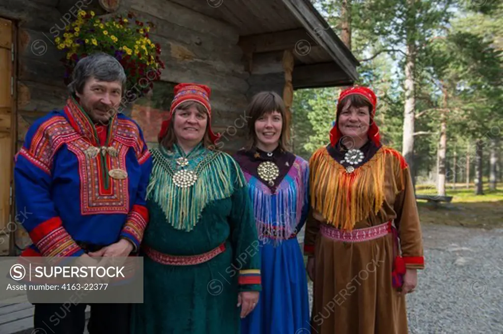Sami Family In Traditional Clothing Near Ivalo, A Village In Inari, Lapland, In Northern Finland