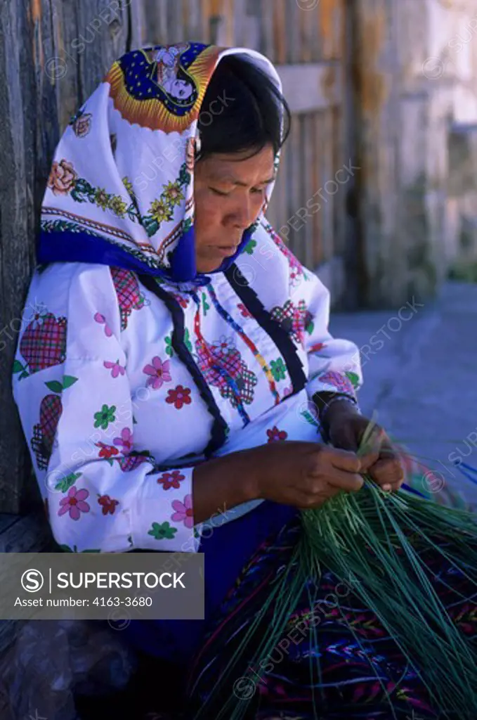 MEXICO, CHIHUAHUA, COPPER CANYON NATIONAL PARK, TARAHUMARA INDIAN WOMAN WEAVING PINE NEEDLE BASKET