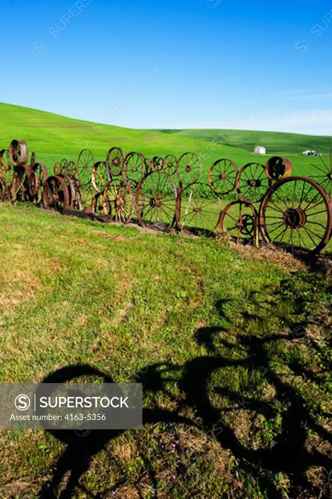 USA, WASHINGTON STATE, PALOUSE, UNIONTOWN, FENCE MADE OUT OF OLD WHEELS AT DAHMEN BARN ART GALLERY