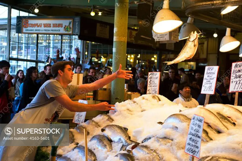 USA, WASHINGTON STATE, SEATTLE, PIKE PLACE MARKET, FRESH SEAFOOD STAND, FLYING FISH SHOW, VENDOR THROWING SALMON