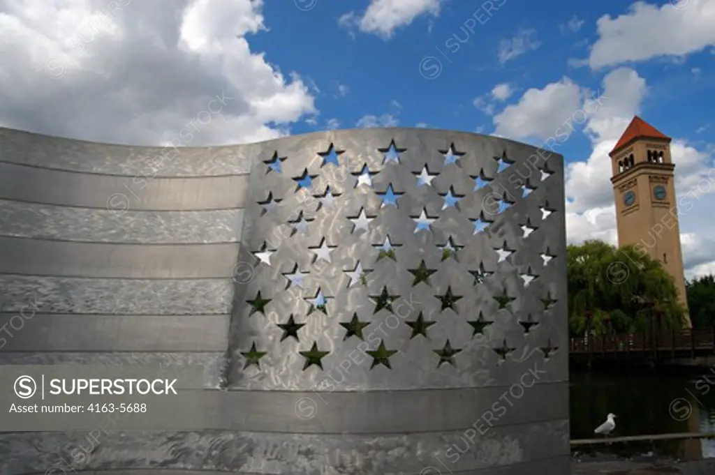 USA, WASHINGTON STATE, SPOKANE, RIVERFRONT PARK, ALUMINUM BENCH (AMERICAN FLAG) ART, CLOCK TOWER IN BACKGROUND